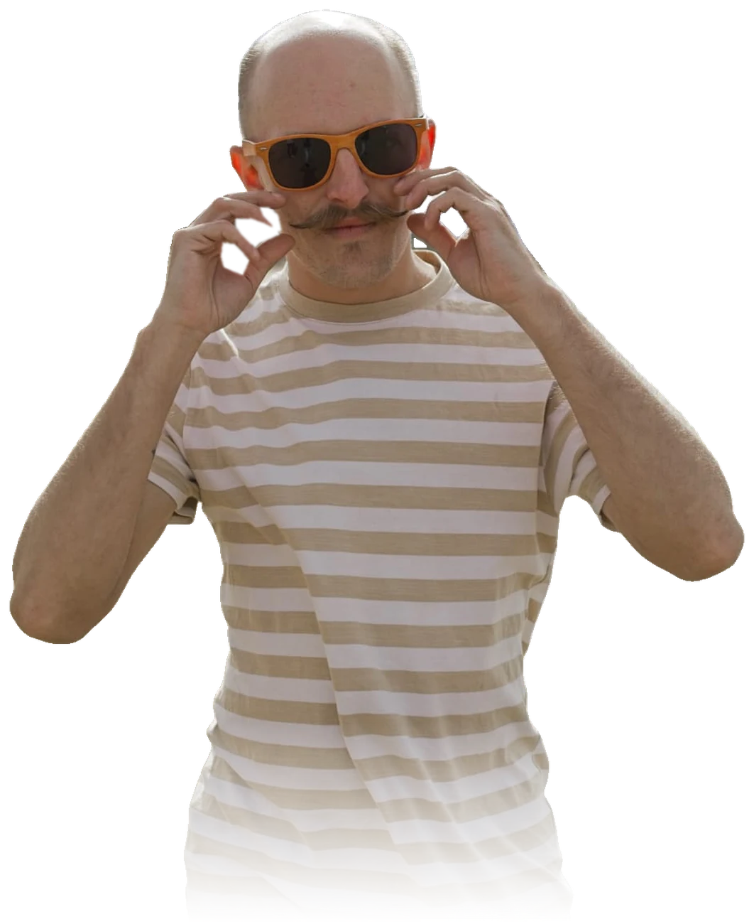 Johan on the beach in orange sunglasses and a striped T-shirt, twirling his moustache with both hands